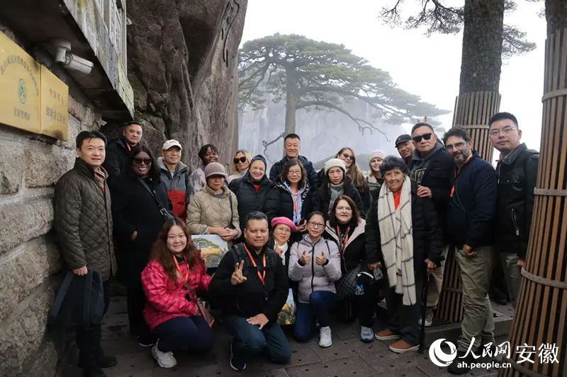 旅行商在黃山迎客松前合影。人民網(wǎng)記者 王曉飛攝