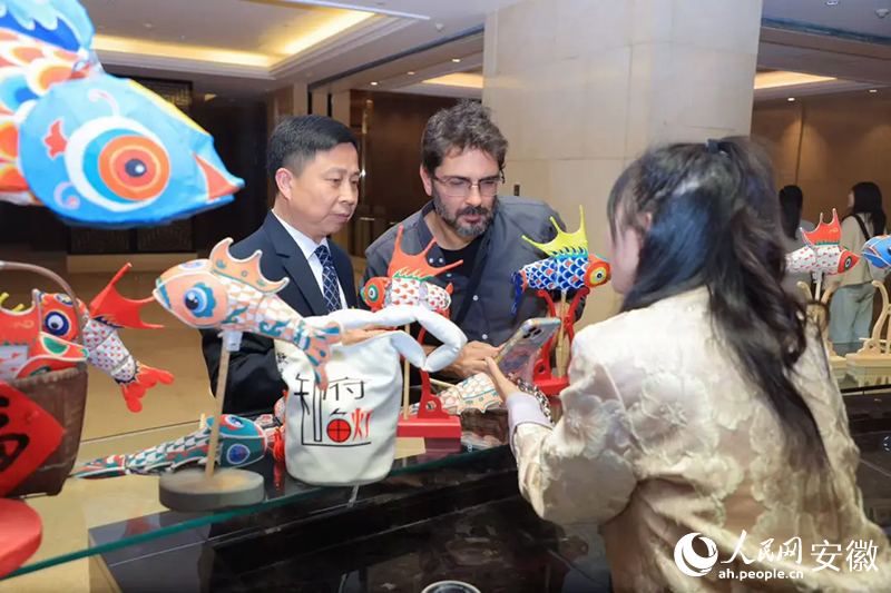 巴西旅行商米內(nèi)維諾·奧爾蒂斯·內(nèi)托·西爾維里奧（中）對魚燈充滿好奇。人民網(wǎng)記者 王曉飛攝